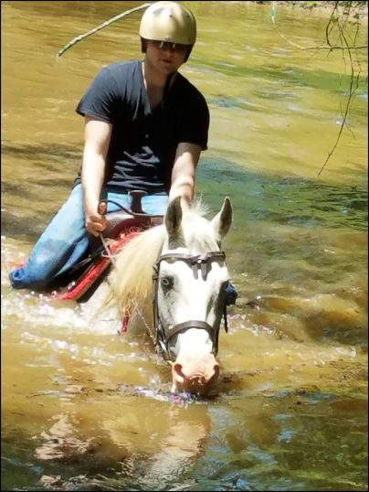 Trail rider at Peavine Creek Farm riding in the pond.